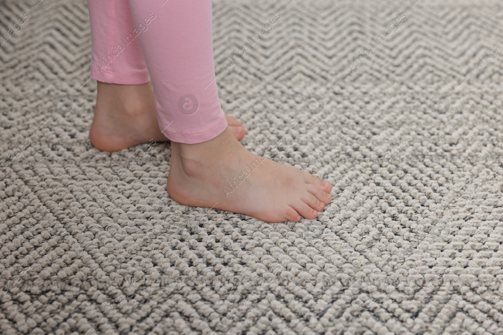 Girl on grey carpet at home, closeup Photo of Girl on grey carpet at home, closeup