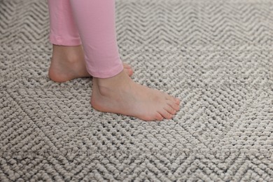 Photo of Girl on grey carpet at home, closeup