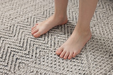Photo of Girl on grey carpet at home, closeup
