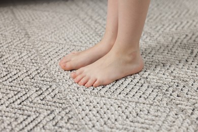 Photo of Girl on grey carpet at home, closeup