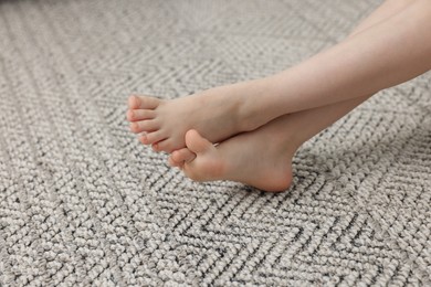 Photo of Girl on grey carpet at home, closeup