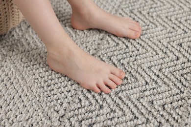 Photo of Girl on grey carpet at home, closeup