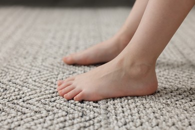 Photo of Girl on grey carpet at home, closeup