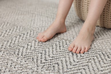 Photo of Girl on grey carpet at home, closeup