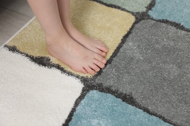 Photo of Girl on soft carpet at home, closeup