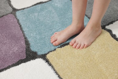 Photo of Girl on soft carpet at home, closeup