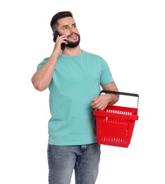 Photo of Man with empty shopping basket talking on smartphone against white background