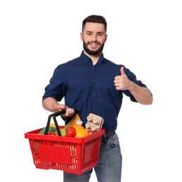 Photo of Man with shopping basket full of products showing thumbs up on white background