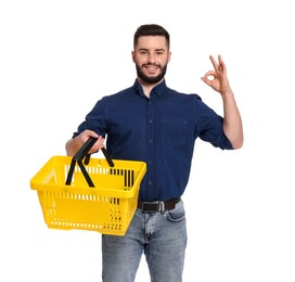 Photo of Man with empty shopping basket showing ok gesture on white background