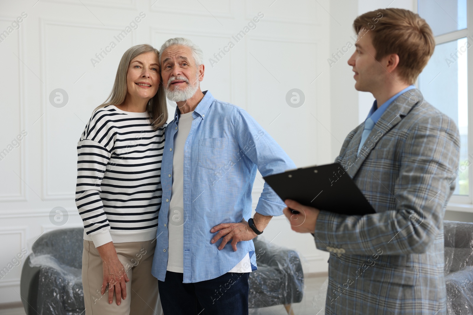 Real estate agent with clipboard and happy couple at home Photo of Real estate agent with clipboard and happy couple at home