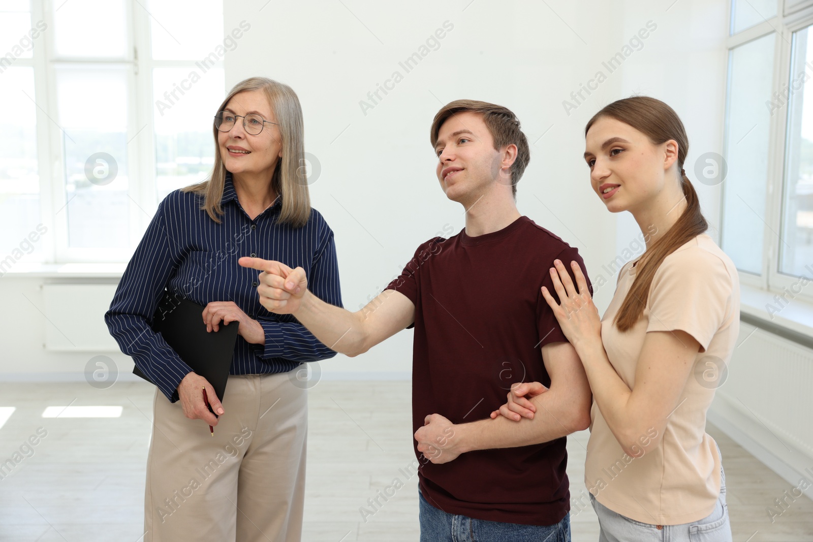 Smiling real estate agent working with couple at home Photo of Smiling real estate agent working with couple at home