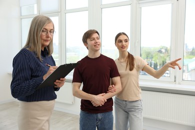 Photo of Real estate agent with tablet working with couple at home