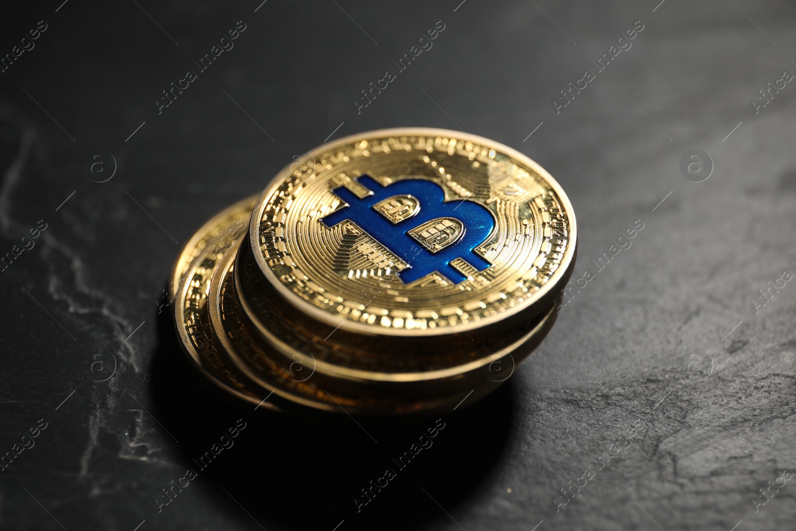Cryptocurrency. Bitcoins on black table, closeup view Photo of Cryptocurrency. Bitcoins on black table, closeup view