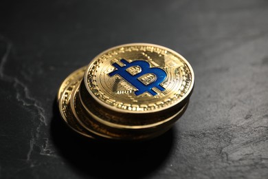 Photo of Cryptocurrency. Bitcoins on black table, closeup view