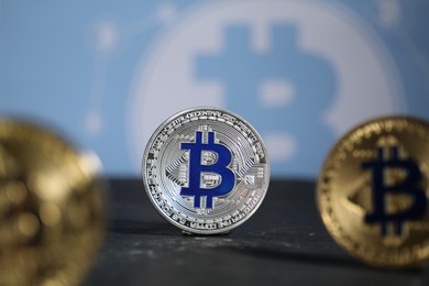 Photo of Cryptocurrency. Three bitcoins on black table, closeup