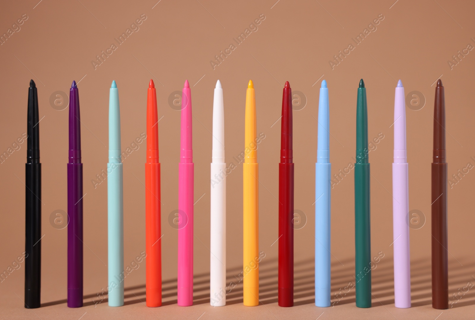 Colorful twist up eye pencils on beige background, closeup Photo of Colorful twist up eye pencils on beige background, closeup