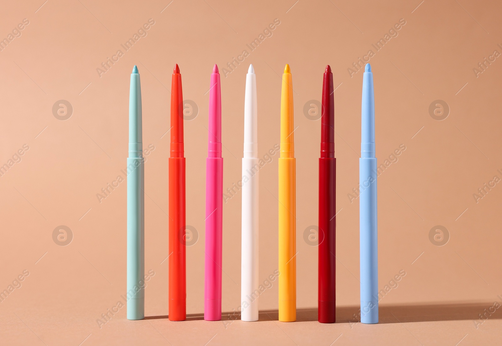 Colorful twist up eye pencils on beige background, closeup Photo of Colorful twist up eye pencils on beige background, closeup