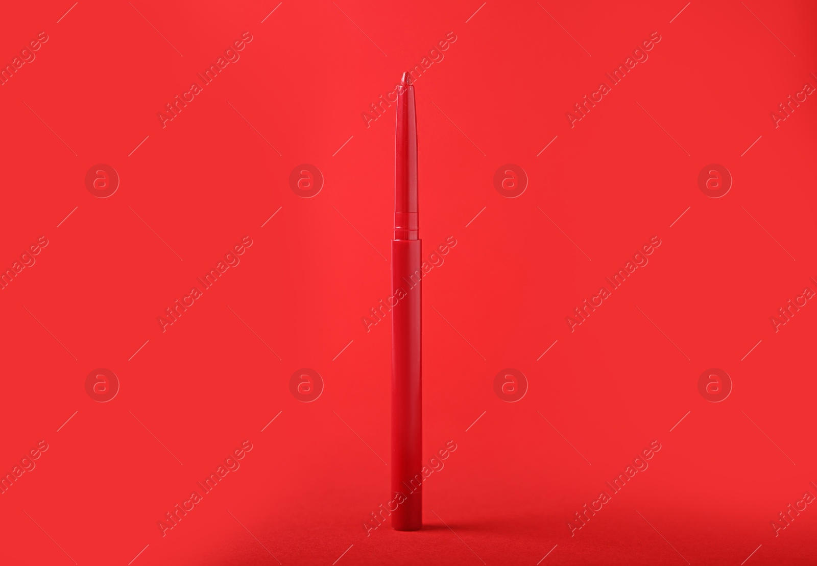 One twist up eye pencil on red background, closeup Photo of One twist up eye pencil on red background, closeup