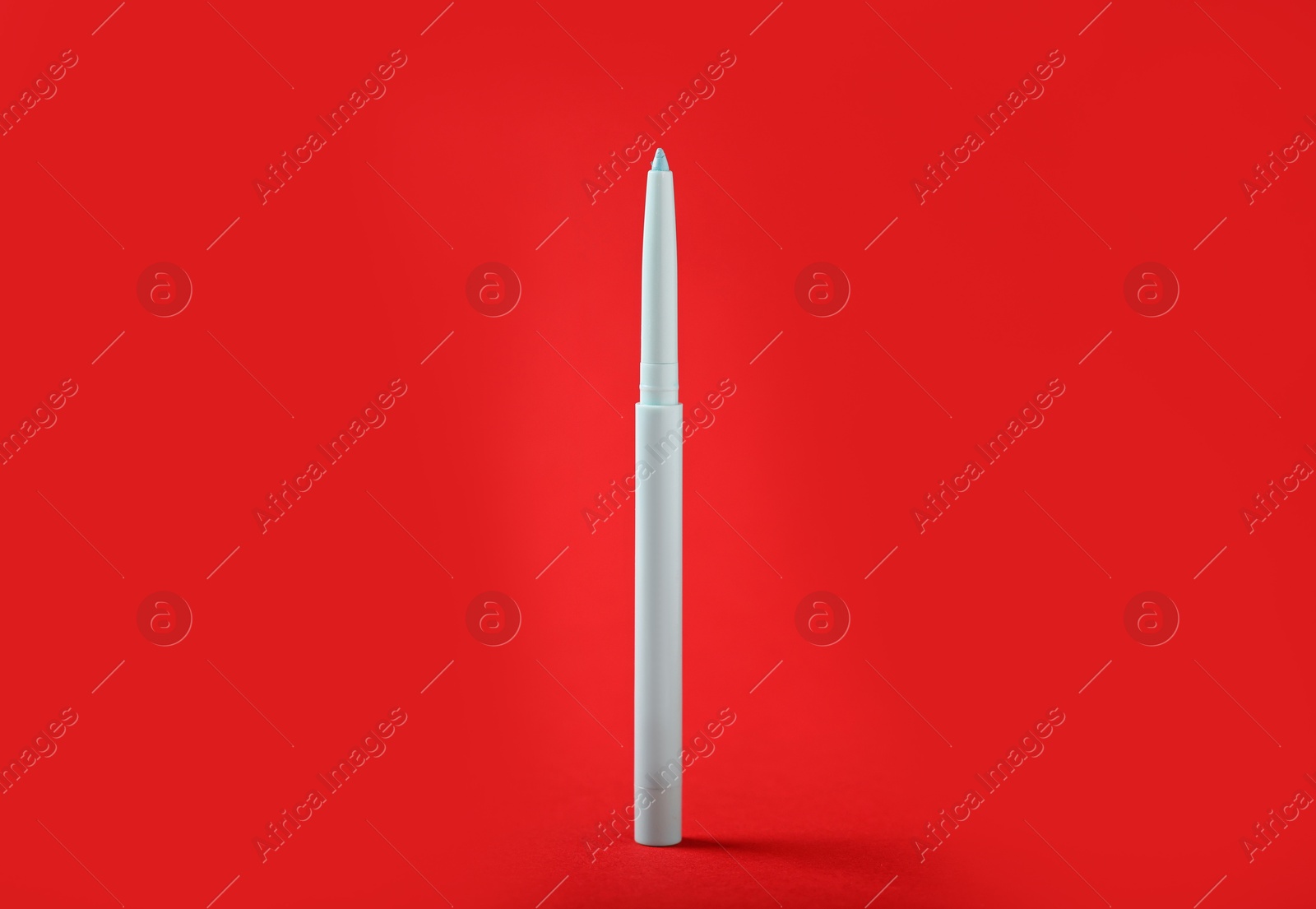 One twist up eye pencil on red background, closeup Photo of One twist up eye pencil on red background, closeup
