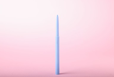 Photo of One twist up eye pencil on pink background, closeup