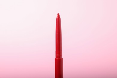 Photo of One twist up eye pencil on pink background, closeup