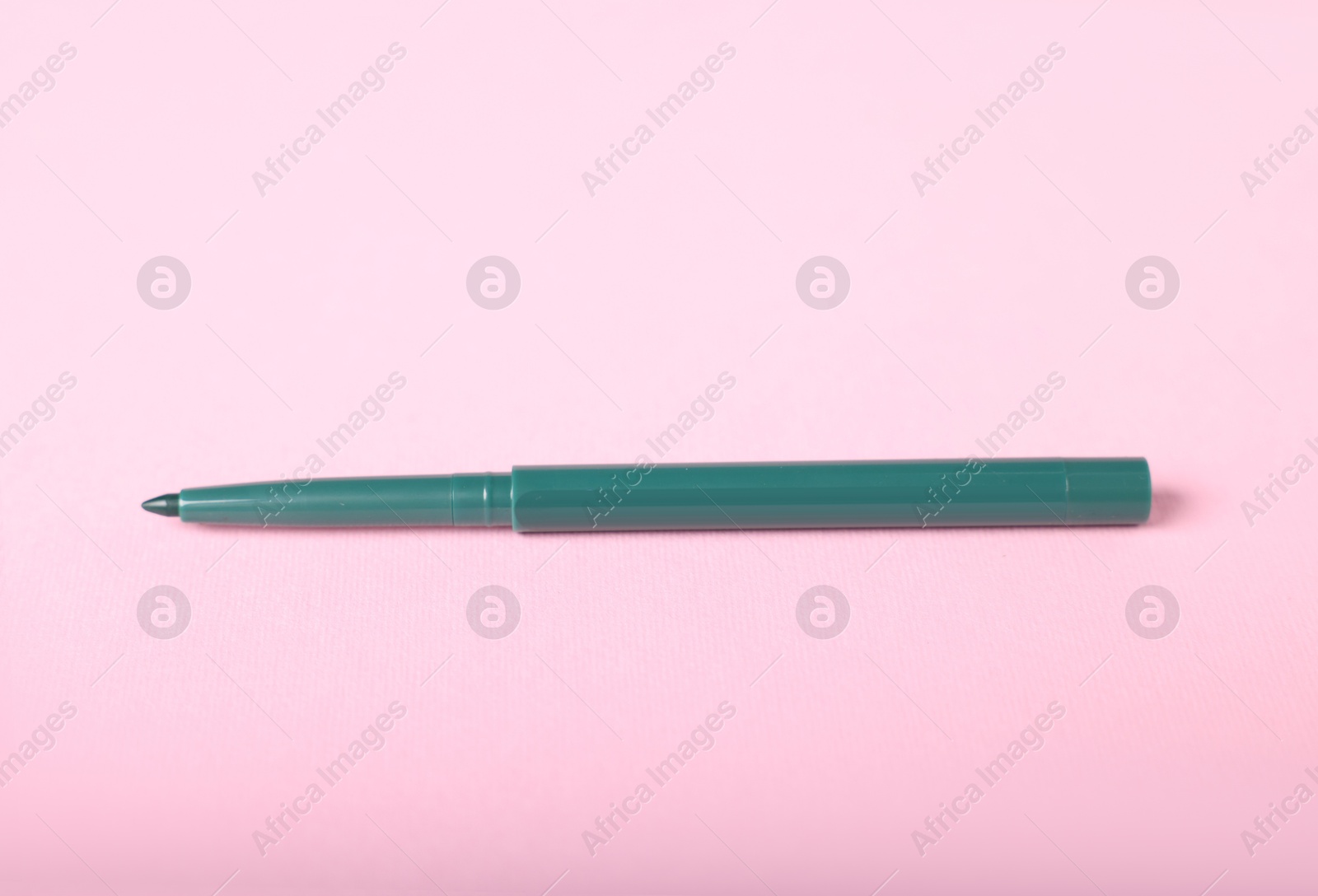 One twist up eye pencil on pink background Photo of One twist up eye pencil on pink background