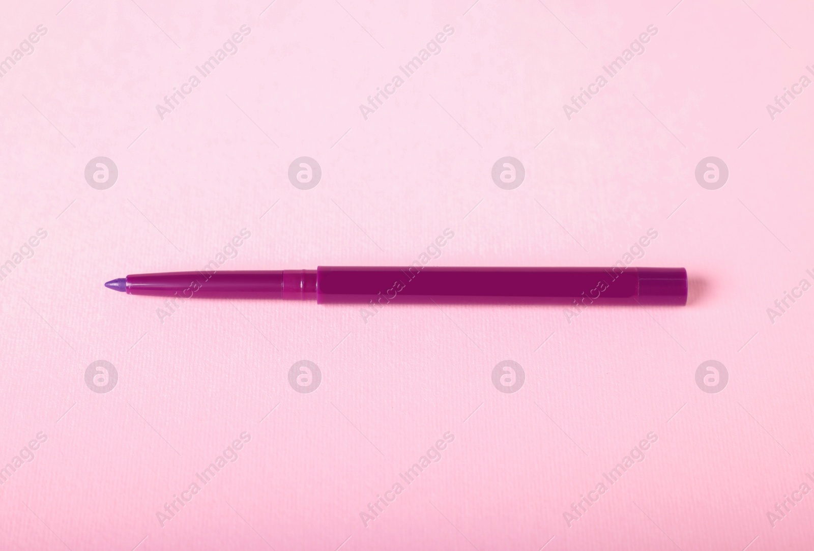 One twist up eye pencil on pink background Photo of One twist up eye pencil on pink background