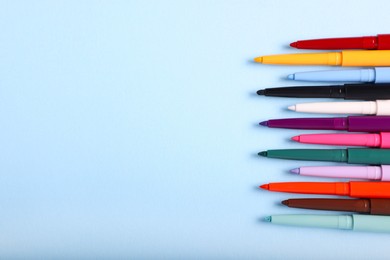 Photo of Colorful twist up eye pencils on light blue background, flat lay. Space for text