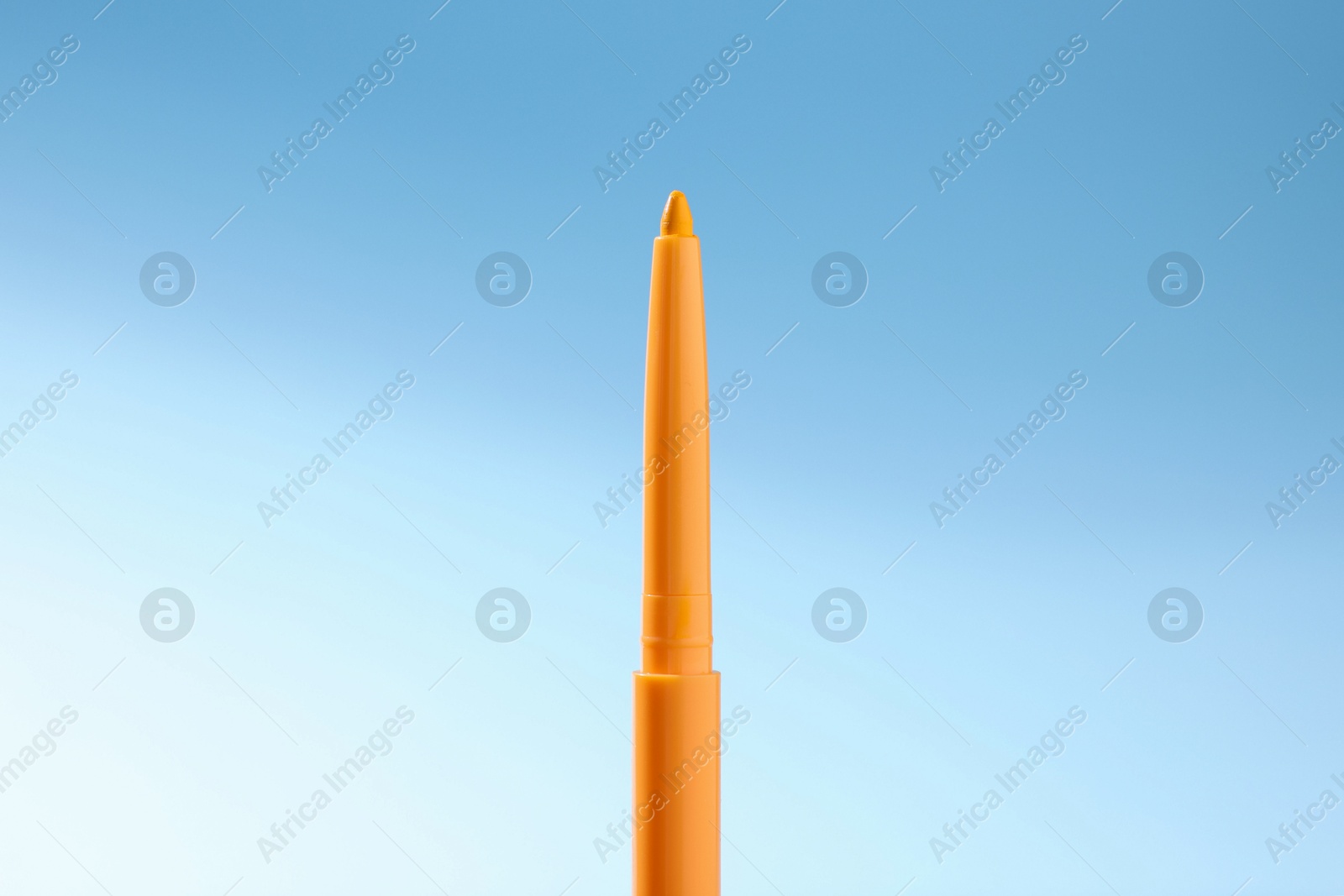 One twist up eye pencil on light blue gradient background, closeup Photo of One twist up eye pencil on light blue gradient background, closeup