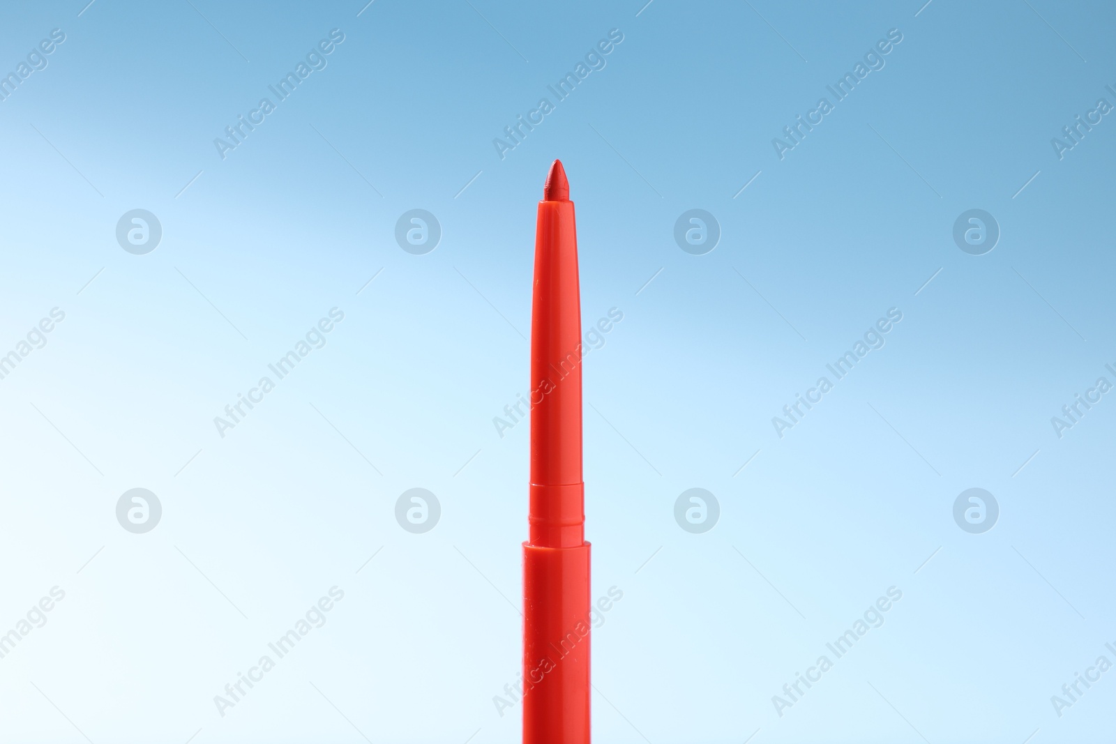 One twist up eye pencil on light blue gradient background, closeup Photo of One twist up eye pencil on light blue gradient background, closeup