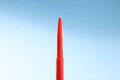 Photo of One twist up eye pencil on light blue gradient background, closeup