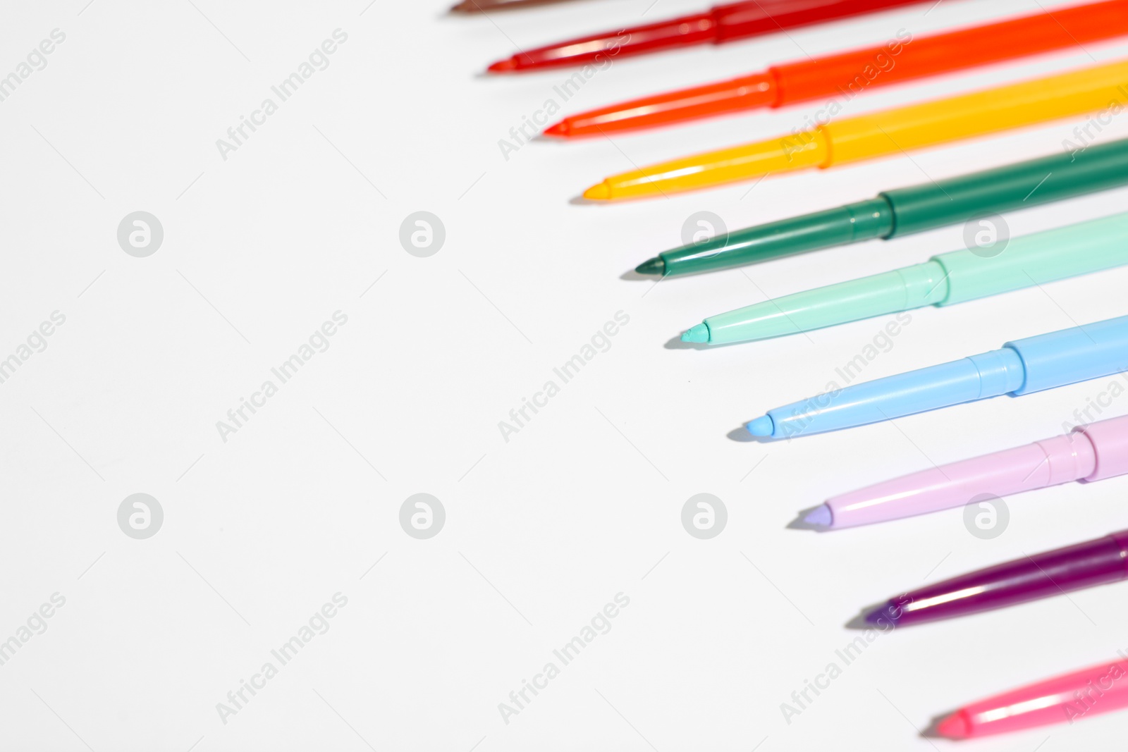 Colorful twist up eye pencils on white background, closeup. Space for text Photo of Colorful twist up eye pencils on white background, closeup. Space for text