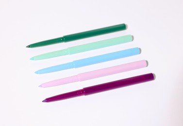 Photo of Colorful twist up eye pencils on white background