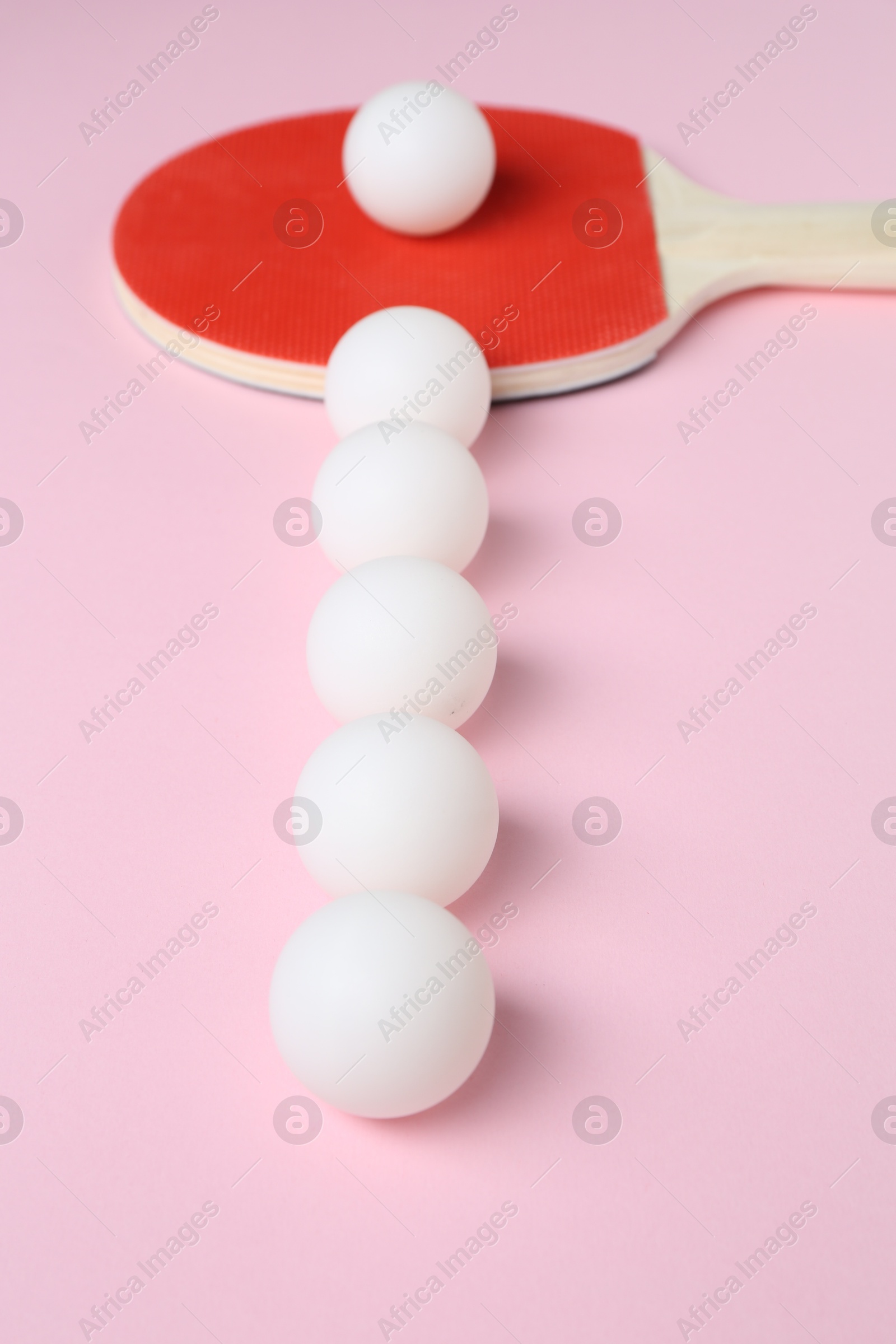 Ping pong racket and balls on pink background, closeup Photo of Ping pong racket and balls on pink background, closeup