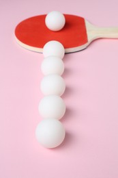 Photo of Ping pong racket and balls on pink background, closeup