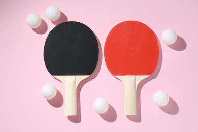 Photo of Ping pong rackets and balls on pink background, flat lay