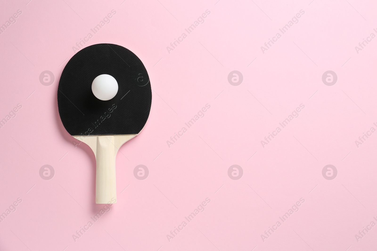 Ping pong racket and ball on pink background, top view. Space for text Photo of Ping pong racket and ball on pink background, top view. Space for text