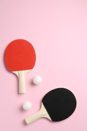Photo of Ping pong rackets and balls on pink background, flat lay. Space for text