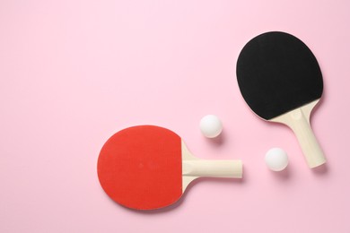 Photo of Ping pong rackets and balls on pink background, flat lay. Space for text