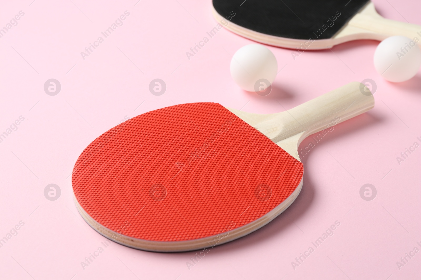 Ping pong rackets and balls on pink background, closeup Photo of Ping pong rackets and balls on pink background, closeup