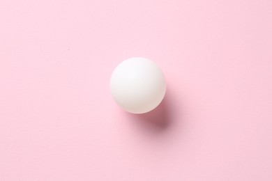 Photo of Ping pong ball on pink background, top view