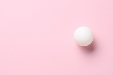 Photo of Ping pong ball on pink background, top view. Space for text