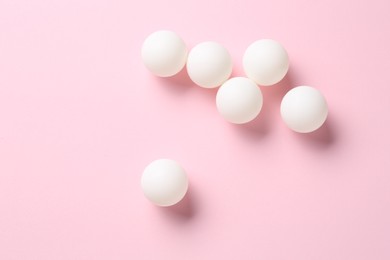 Photo of Many ping pong balls on pink background, flat lay