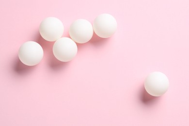 Photo of Many ping pong balls on pink background, flat lay