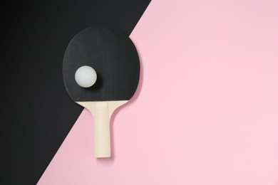 Photo of Ping pong racket and ball on color background, top view. Space for text