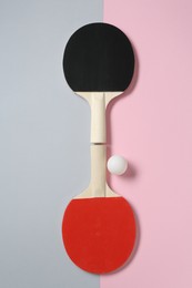 Photo of Ping pong rackets and ball on color background, flat lay