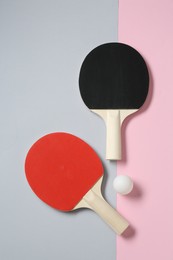 Photo of Ping pong rackets and ball on color background, flat lay