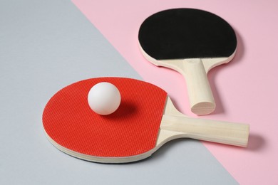Photo of Ping pong rackets and ball on color background, closeup