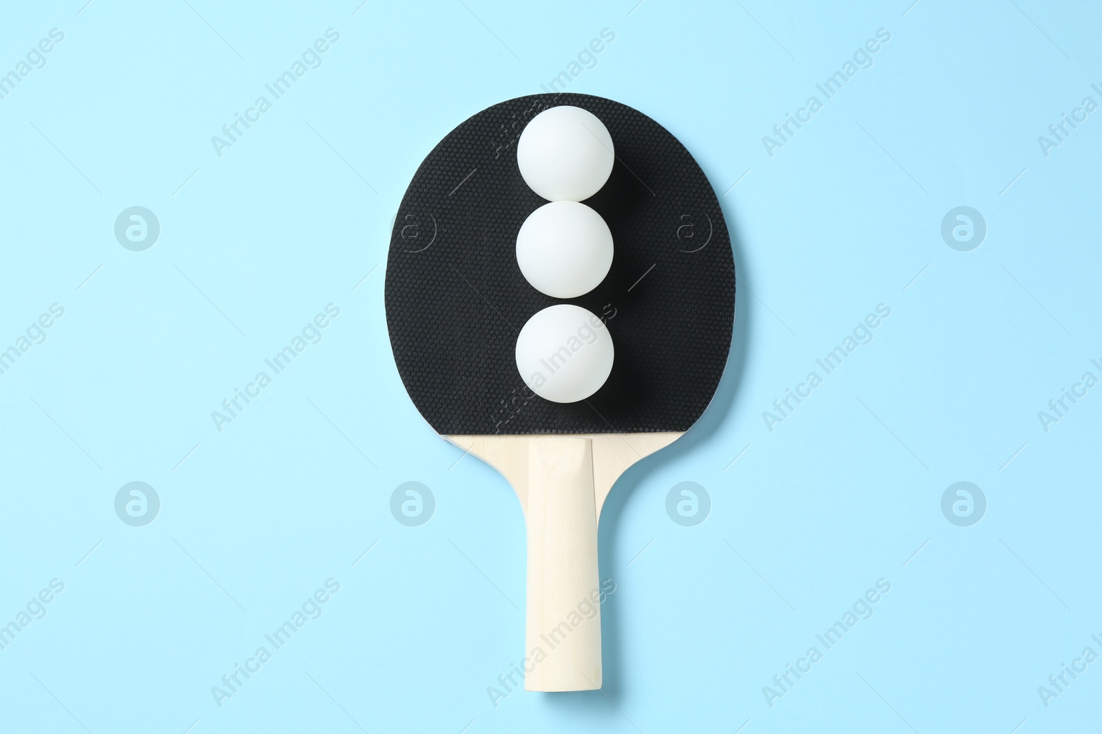 Ping pong racket and balls on light blue background, top view Photo of Ping pong racket and balls on light blue background, top view