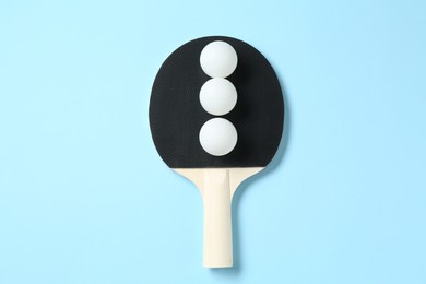 Photo of Ping pong racket and balls on light blue background, top view